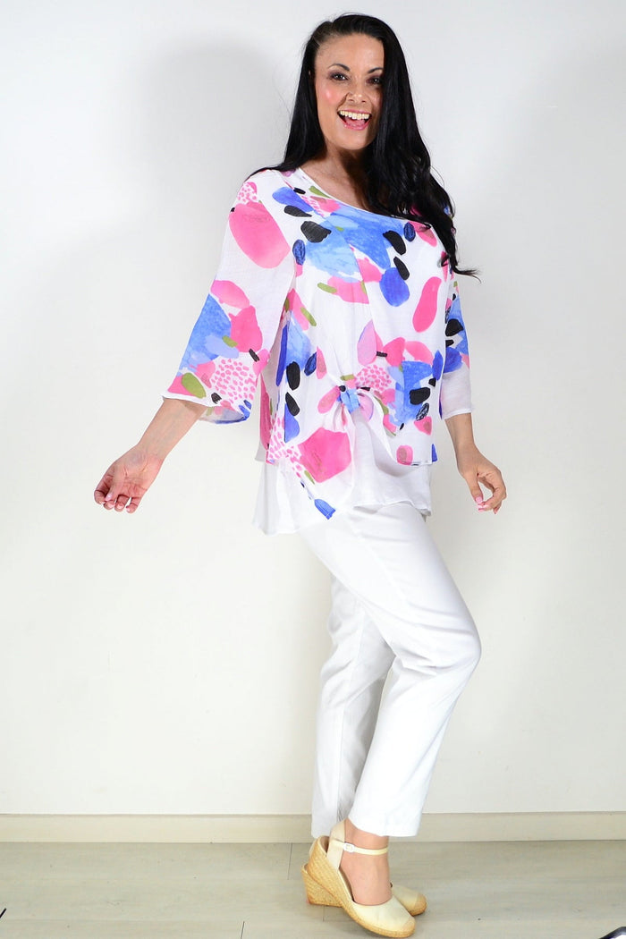 Pink and blue paint splash tunic top from Wishstone, featuring a flowing fabric and vibrant artistic design.