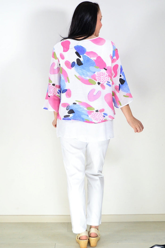 Pink and blue paint splash tunic top by Wishstone, featuring a relaxed fit and artistic design, shown on a model.
