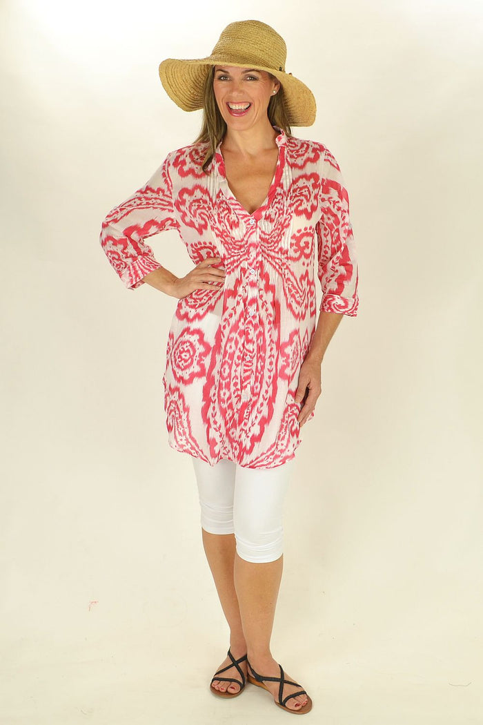 Red Rosa tunic by sunnsand featuring a relaxed fit and flowing fabric, displayed on a hanger against a neutral background.