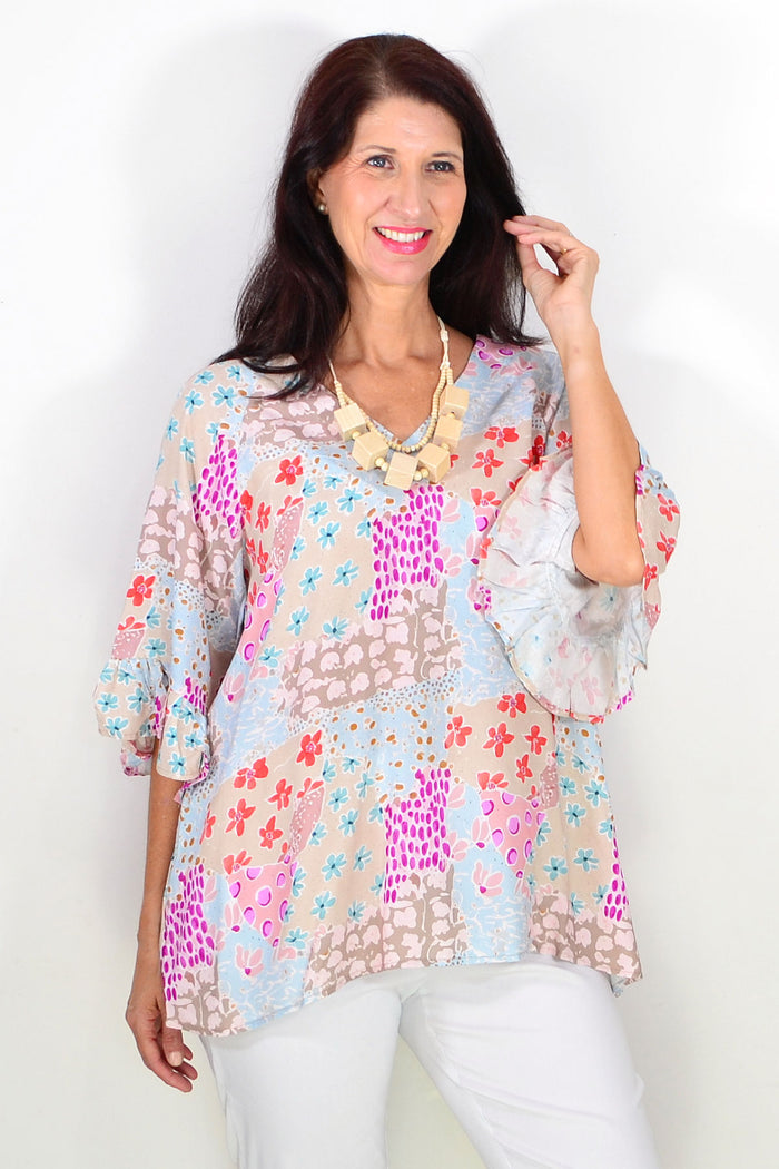 Wishstone relaxed soft floral tunic top with a loose fit and vibrant floral pattern, displayed on a hanger against a neutral background.