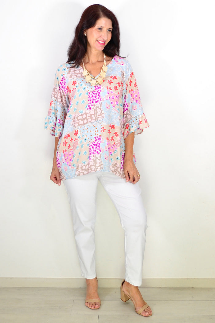 Relaxed soft floral Wishstone tunic top with a flowy fit and vibrant floral pattern, displayed on a hanger.