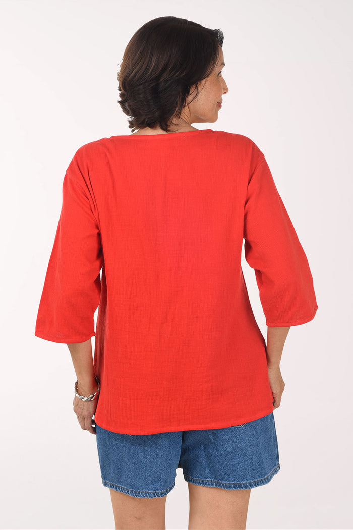 Woman wearing a red top and denim skirt on a white background