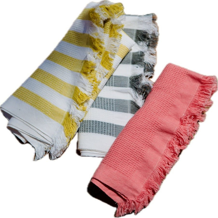 Three rolled cotton waffle weave hand  towels in pink, yellow and white stripe and grey and white stripe.