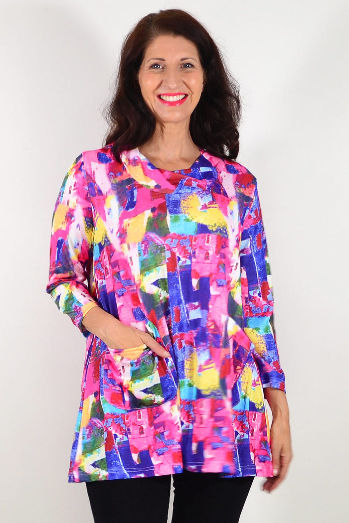 Wishstone Splash Of Colour tunic top with vibrant, abstract pattern, long sleeves, and relaxed fit displayed on a hanger.