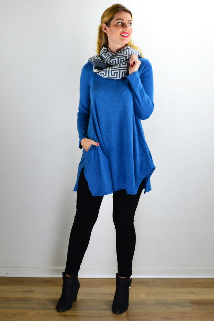 Teal blue knit tunic top by Hourglass, featuring a comfortable fit and textured fabric, worn with casual accessories.
