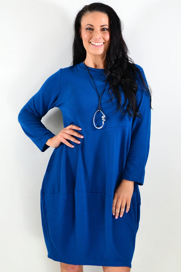 Teal Peony Cocoon Winter Pocket Tunic Dress displayed on a hanger showing its cozy, relaxed fit and large front pockets.