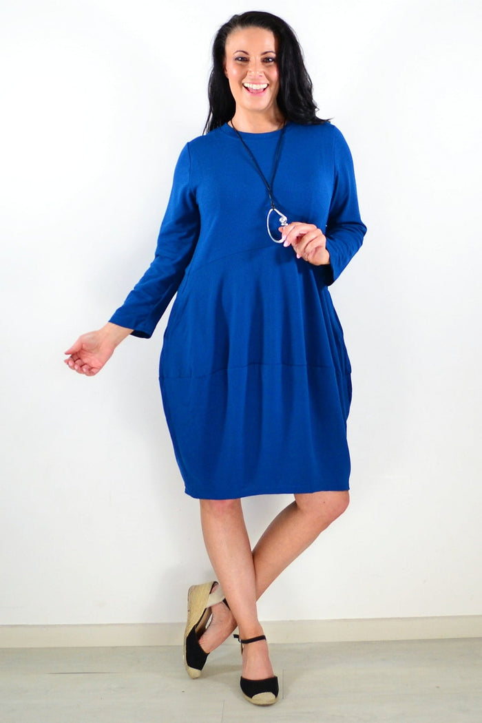 Peony teal cocoon winter pocket tunic dress displayed on a hanger, showcasing its cozy, oversized fit and side pockets.