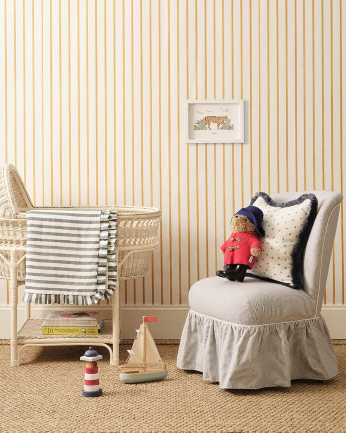 A white framed print of a tiger walking through green foliage on the wall of nursery with crib and toys around - ANNIE.G