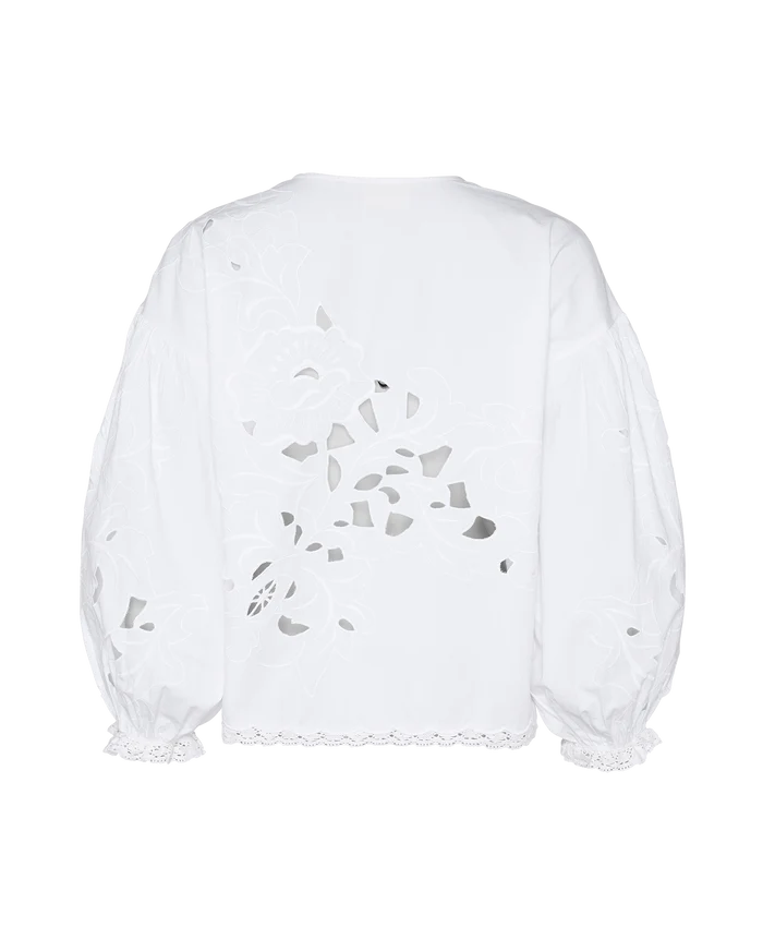 Back of a white top with long sleeves and front ties with cutwork embroidery.