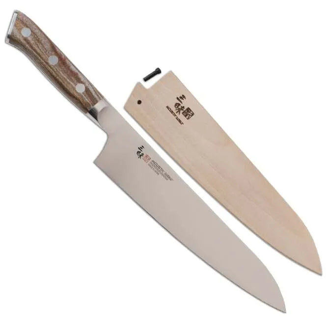 A Zanmai Pro Gyuto SE knife with a distinctive handle pattern and a natural wood saya cover.