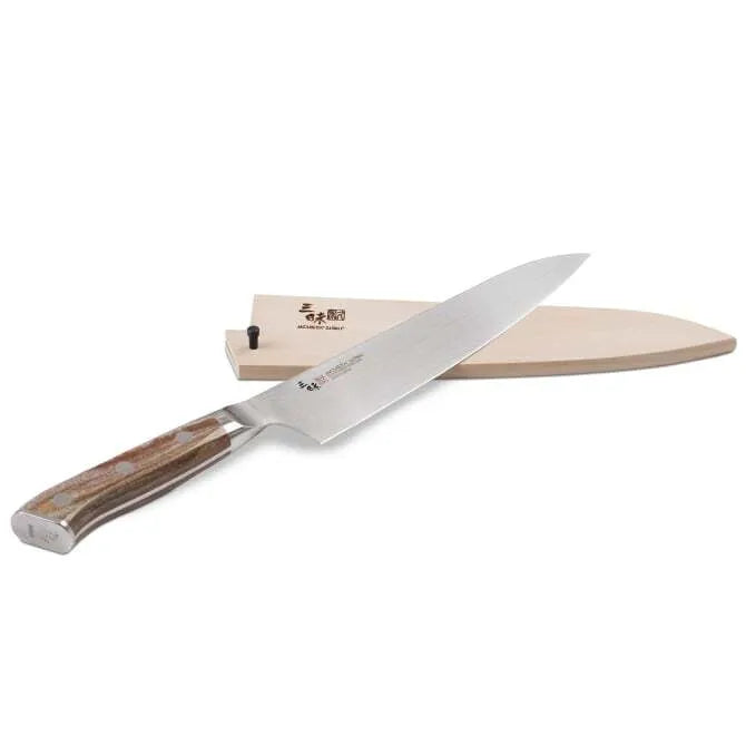 A Zanmai Pro Gyuto SE knife with a distinctive handle pattern and a natural wood saya cover.