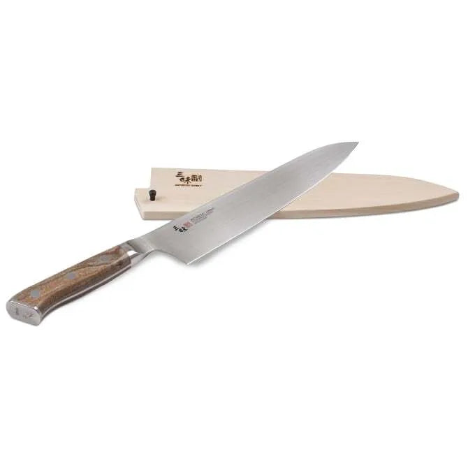 A Zanmai Pro Gyuto SE knife with a distinctive handle pattern and a natural wood saya cover.