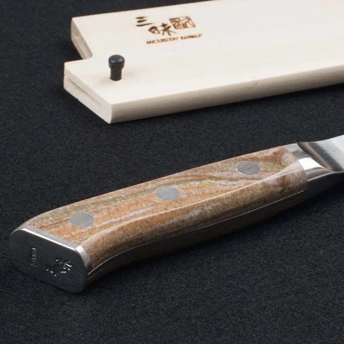 A Zanmai Pro Gyuto SE knife with a distinctive handle pattern and a natural wood saya cover.